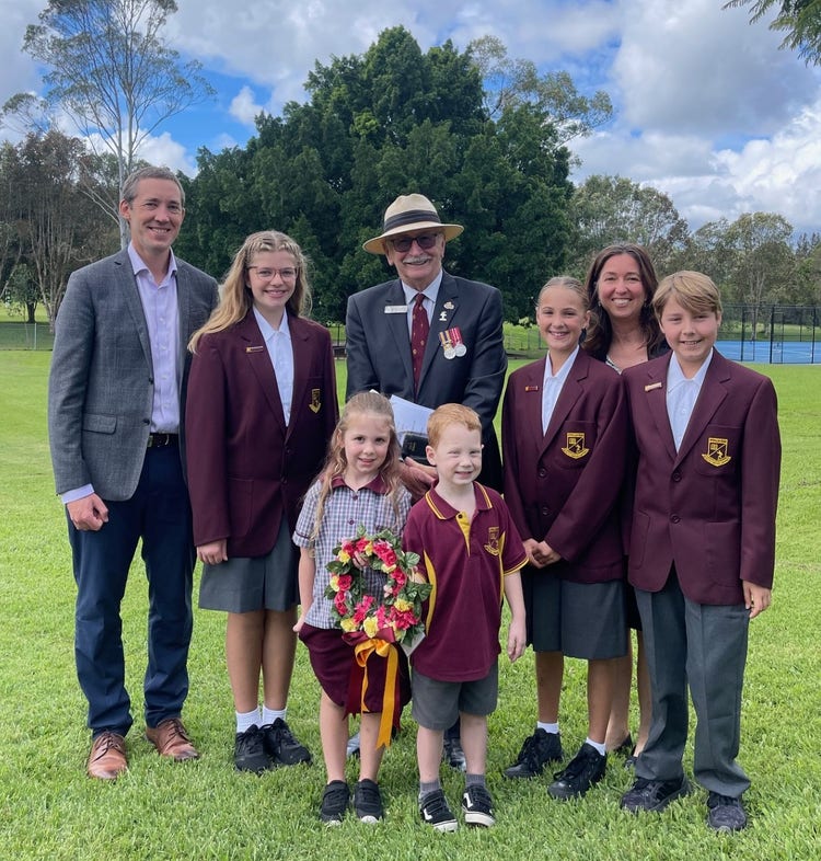 An image of the school captains, principal, two kinder students holding a wreath and a representative from the RSL